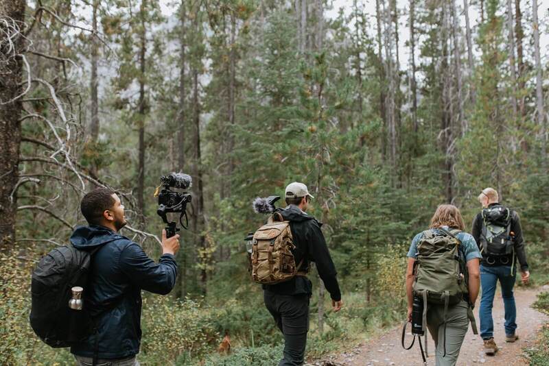 The Little Symphony team recording in a forest recording video and sound.